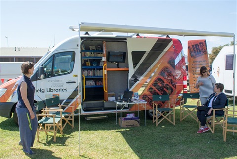 Library to go van with people sitting outside